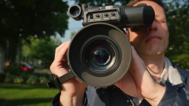 Een close-up shot van een cameraman gericht een schouder-gemonteerde camera. — Stockvideo