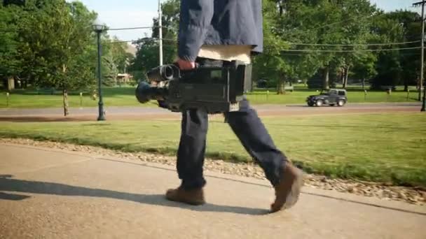 生産に彼のビデオカメラを運ぶカメラマンのローアングル ショット. — ストック動画