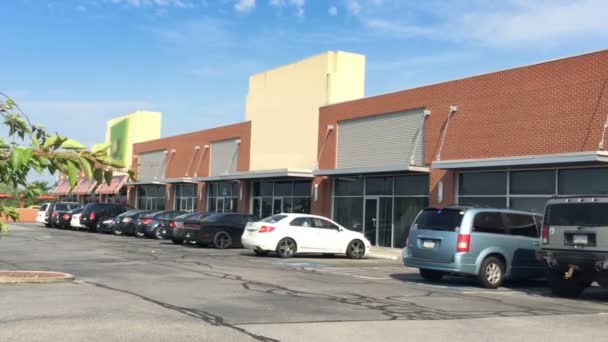 Una toma de un estacionamiento en un centro comercial. Logotipos de tienda eliminados para uso general . — Vídeos de Stock