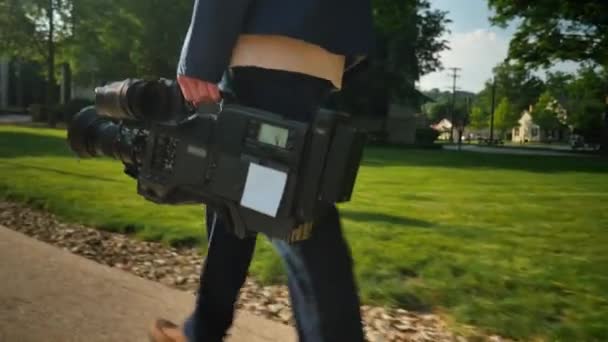 Снимок оператора, несущего свою видеокамеру на съёмки. Отслеживаемый самолет на камере для размещения индивидуального логотипа . — стоковое видео