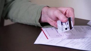 bir adam kredi kartını keser.