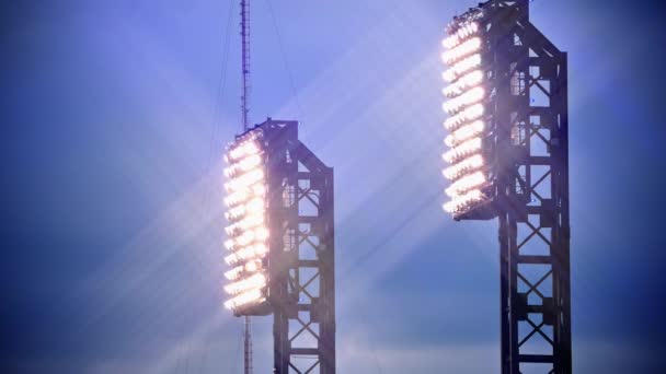 Le luci dello stadio brillano al tramonto con i riflessi delle lenti — Video Stock