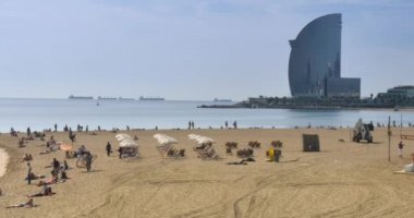 Ziyaretçiler erken Sonbahar'da Barselona güneşli plajları tadını çıkarın.