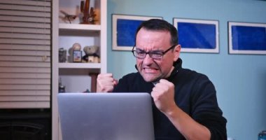 Sinirli adam yumruk Laptop sallıyor.