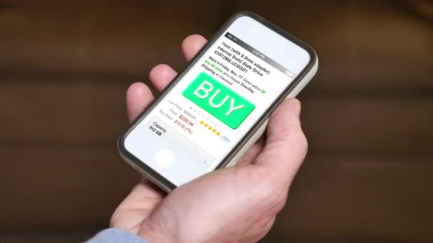 Aankoop van een item met een smartphone app. generieke telefoonapparaat tonen een fictieve storefront interface. — Stockvideo