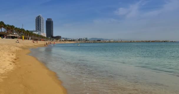 Bezoekers genieten van de zonnige stranden van Barcelona in de vroege herfst. — Stockvideo