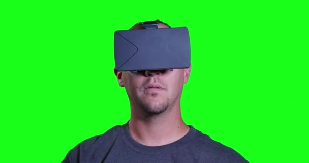 Een man in een virtuele realiteit masker kijkt rond en zijn omgeving manipuleert. — Stockvideo