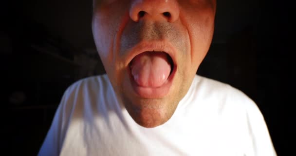 En extrem närbild på en man att sätta ett piller i munnen. — Stockvideo