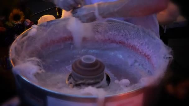 Verkäufer auf einer Messe bereitet Zuckerwatte für einen Kunden zu. — Stockvideo