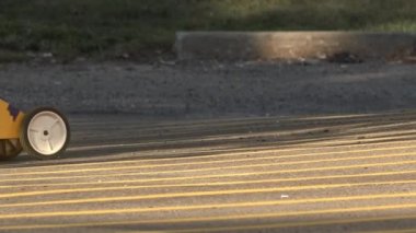 Yeni sarı çizgiler üzerinde bir park yeri boyama.