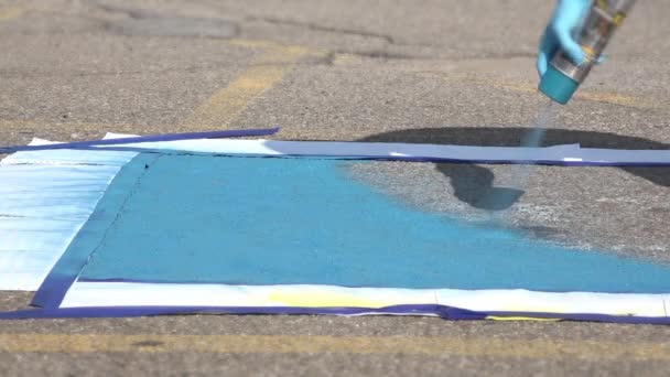 Pintura de una plaza de aparcamiento para discapacitados azules . — Vídeos de Stock