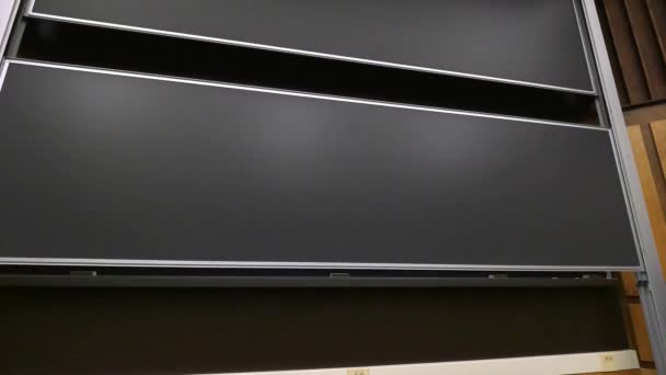 大学の教室の前に大きな黒板が上昇します。. — ストック動画
