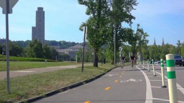 İki üniversite çağındaki çocuklar Schenley Park Pittsburgh, PA atış vasıl 60 fps Oakland alanında bir bisiklet lane onların bisiklet sürmek.