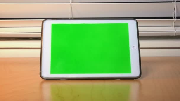 Una persona se enciende y luego toca la pantalla de un iPad. Pantalla verde con luma mate para la colocación de pantalla personalizada . — Vídeos de Stock