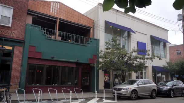 Eine allgemeine Einspielung eines Restaurants und Geschäfts auf einer Stadtstraße. — Stockvideo