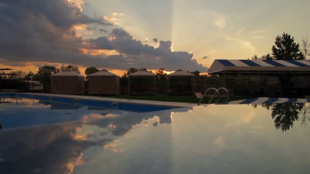 Reflekterade solnedgång och moln över poolen timelapse — Stockvideo