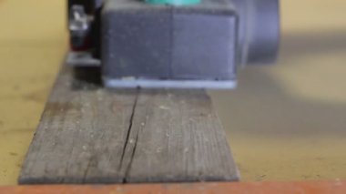 Marangoz ahşap bir tahta ile elektrik uçak yakın çekim yenileyen