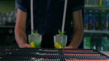 Barmen iki taze kokteyl barda koyar.