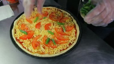 Şef yeşil fasulye pizza üzerine koyar.