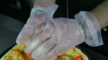 Şef dilimlenmiş soğan bir pizza üzerine koyar.
