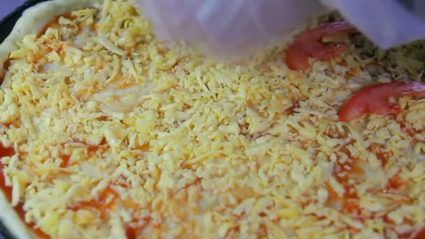 El chef pone tomates picados en una pizza en blanco — Vídeo de stock
