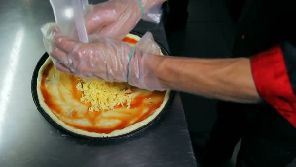 Chef menuangkan keju di pizza kosong — Stok Video