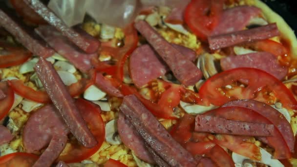 Pizzaiolo giet gesneden ui op een pizza — Stockvideo