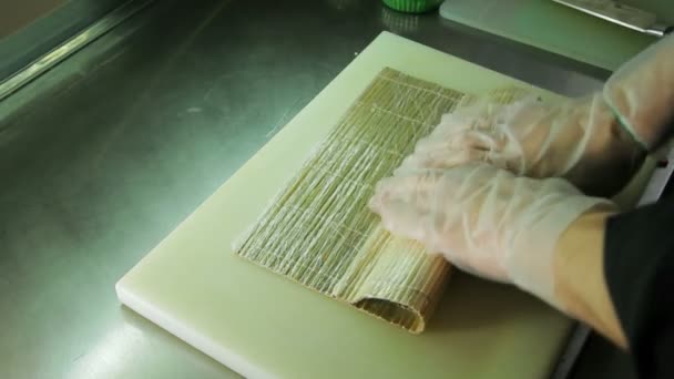 Enrouler le rouleau de sushi avec tapis de bambou, vue à l'envers — Video