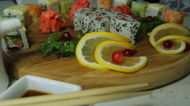 Κουκλίτσα πυροβολισμό νόστιμο σούσι κυλίνδρους στο ξύλινο πιάτο με wasabi και τζίντζερ — Αρχείο Βίντεο