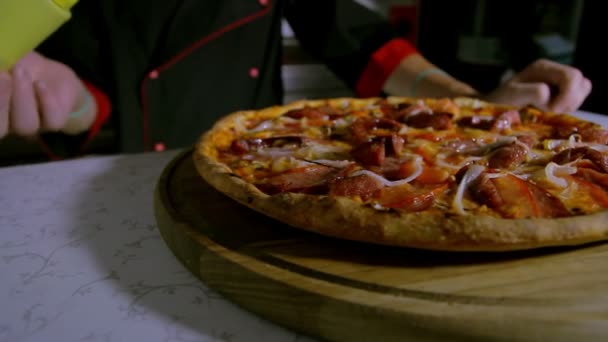 Pizzaiolo streut Oregano auf Pizza — Stockvideo