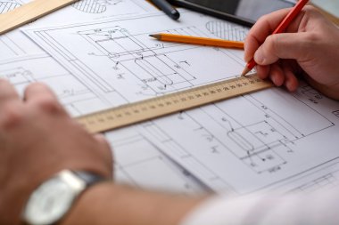Adam mimar Ofis Masası, kağıt üzerine büyük kalem tarafından bir plan, grafik, tasarım, geometrik şekiller çizer. Yumuşak odak.