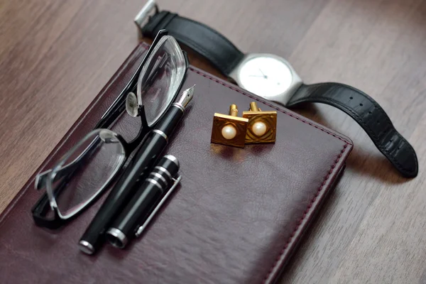 Бізнес-аксесуари на робочому столі: блокнот, щоденник, ручка для фонтану, окуляри, годинник. Макрос з розмиттям і м'яким фокусом — стокове фото