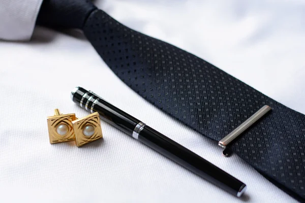 Деловые аксессуары (запонки, перо, планшет, телефон, очки, блокнот) в мужской классической белой рубашке с галстуком — стоковое фото