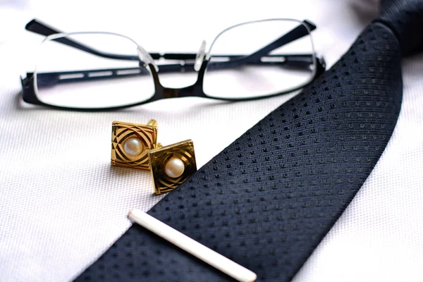 Деловые аксессуары (запонки, перо, планшет, телефон, очки, блокнот) в мужской классической белой рубашке с галстуком — стоковое фото