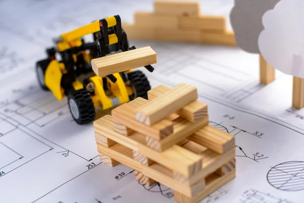 Mesin konstruksi mainan membangun rumah dari balok kayu (bar) di gambar-gambar . Stok Gambar