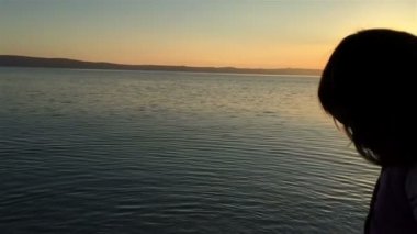 Küçük kız denize taş atan görünümünü ağır çekim