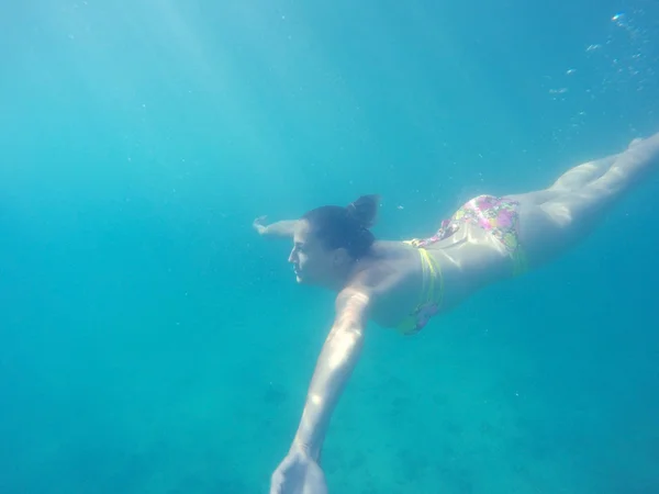 Mujer joven nadando bajo el agua — Foto de Stock