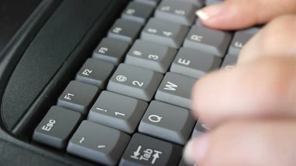Закройте женские пальцы, печатая на клавиатуре — стоковое видео
