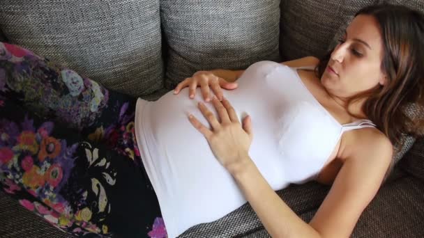 Gravid kvinna liggande på soffan — Stockvideo