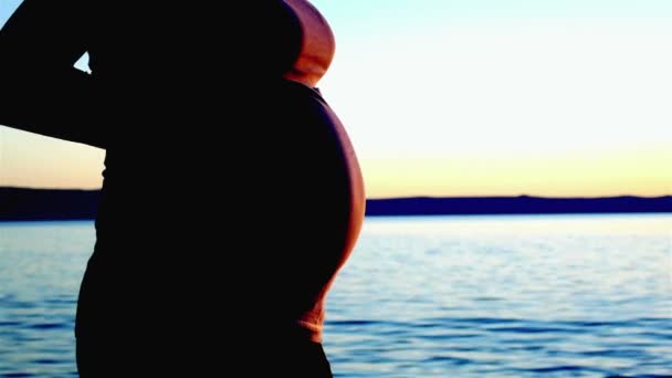 Mulher grávida tocando barriga no pôr do sol — Vídeo de Stock
