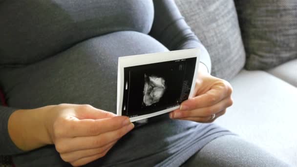 Gravid kvinna med ultraljudsbilder — Stockvideo