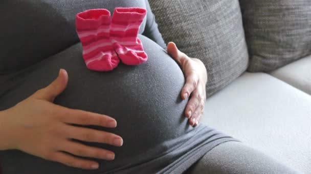 Mujer embarazada con calcetines de bebé — Vídeos de Stock