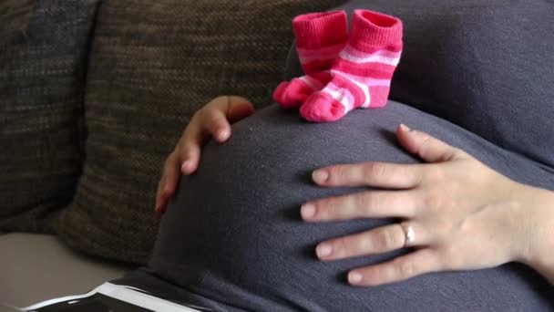Женщина трогает беременный живот и смотрит ультразвук — стоковое видео