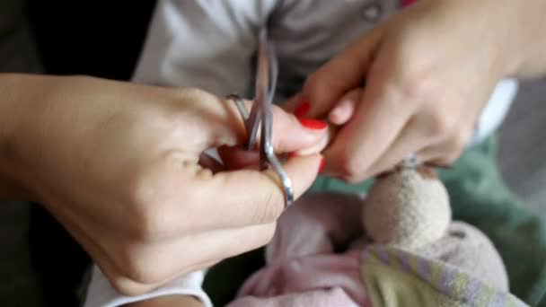 Мать стрижет ногти дочери — стоковое видео
