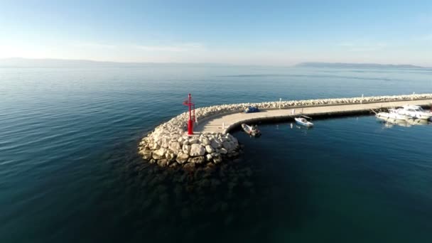 Volando sobre la luz roja del faro en la entrada del puerto — Vídeos de Stock