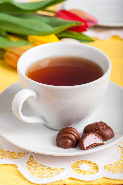 Una taza de té con caramelos de chocolate en forma de huevo de Pascua — Foto de Stock