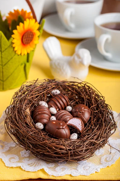 Dulces de chocolate en forma de huevo de Pascua en un nido — Foto de Stock
