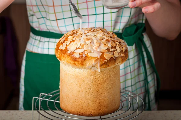 Una mujer rociando pan de Pascua con hielo de azúcar — Foto de Stock