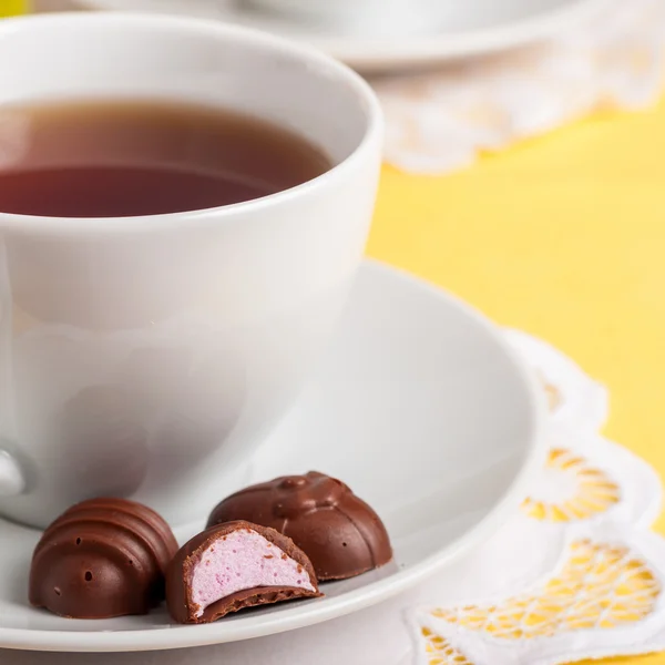 Uma xícara de chá com ovos de Páscoa em forma de doces de chocolate — Fotografia de Stock