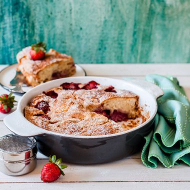 Dilimlenmiş taze çilekli kek seramik tavada pişirilmiş, kare.